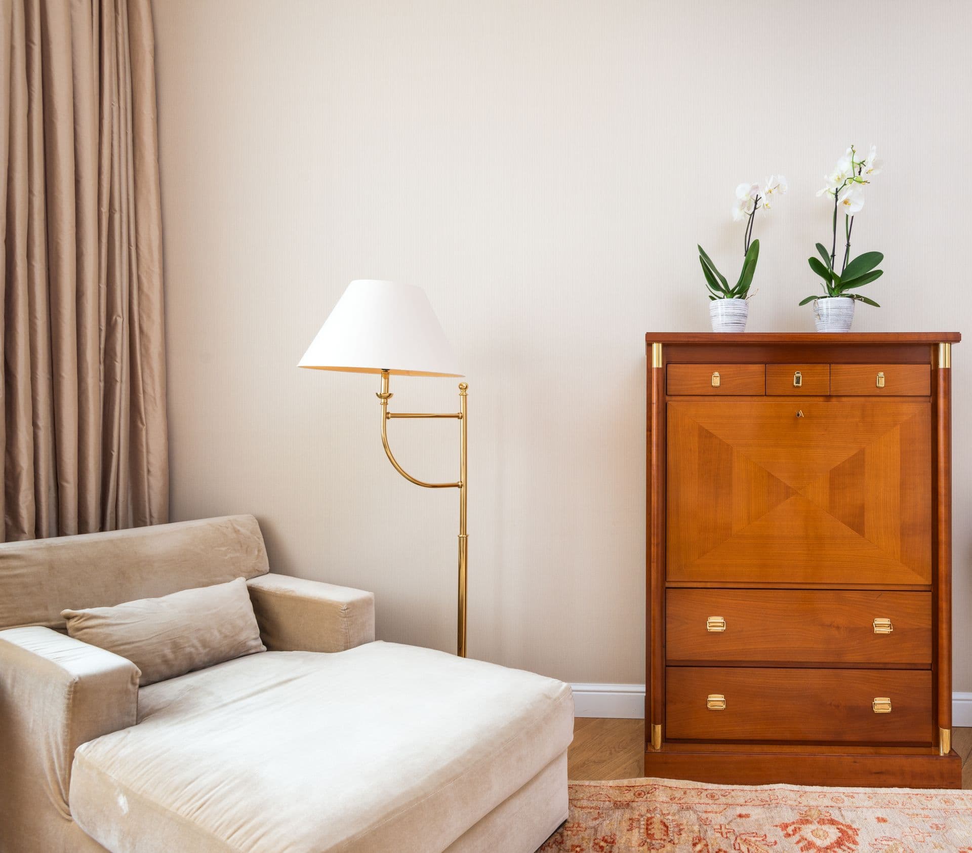 Intérieur doux aux tons beiges avec fauteuil et orchidées